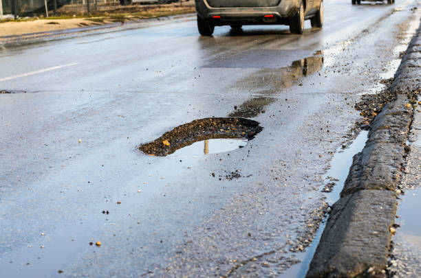 istock Big pothole on road after winter 1140193768