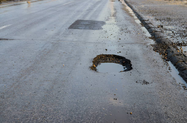 istock Big pothole on road after winter 1140194076