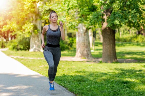istock Beautiful young female jogging in the park 1140195156