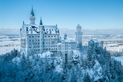 The view over Salzburg, Austria on a bright spring evening.  In the foreground are church spires of the Cathedral and the Hohensalzburg fortress with snow covered mountains of the Alps.