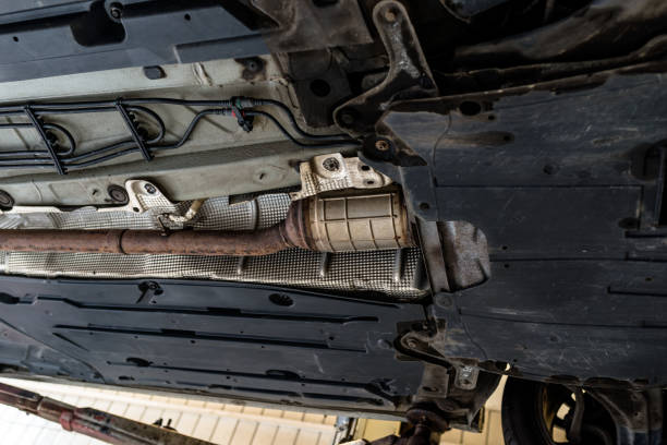 The exhaust system in the car seen from below, the car is on the lift in the car workshop. The exhaust system in the car seen from below, the car is on the lift in the car workshop. plug adapter stock pictures, royalty-free photos & images