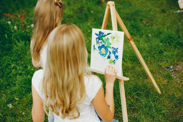 istock Mother with daughter drawing in a park 1140199323