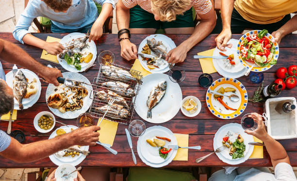 stor miltigeneration familje middag i processen. topp visa vertikal bild på bord med mat och händer - dinner croatia bildbanksfoton och bilder