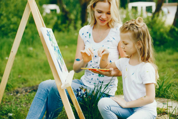 istock Mother with daughter drawing in a park 1140199879