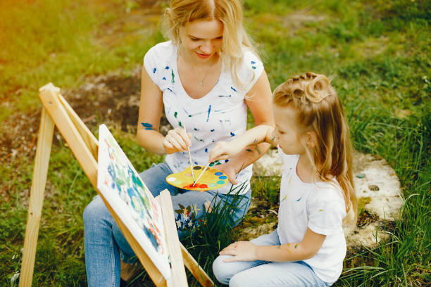 istock Mother with daughter drawing in a park 1140200068