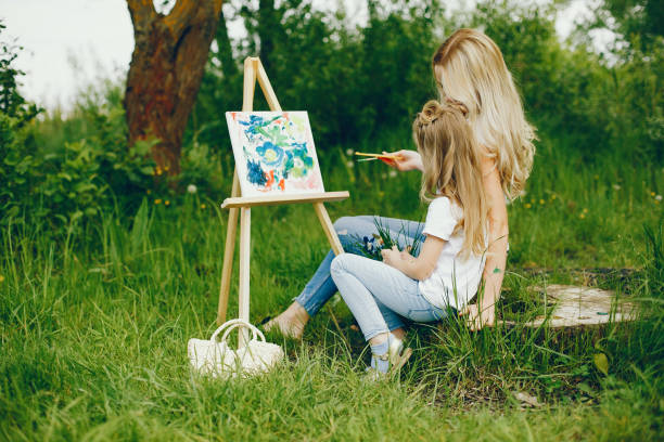istock Mother with daughter drawing in a park 1140200123
