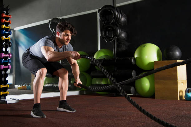istock Athletic Young Man Doing Exercise with Battle Rope in Gym 1140200341