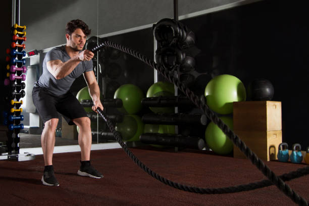 istock Young Athlete Doing Exercise with Battle Rope in Gym 1140203221