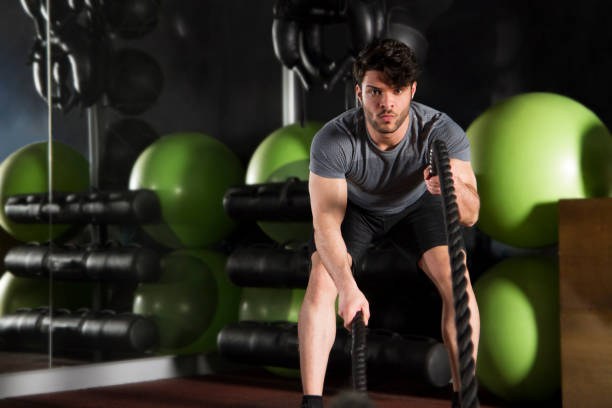 istock Young Athlete Doing Exercise with Battle Rope in Gym 1140203992