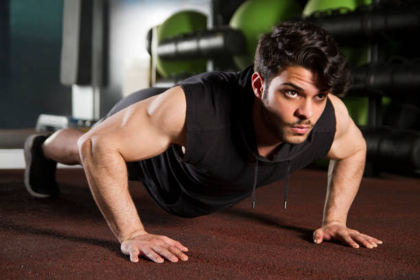 istock Young Handsome Man Doing Push-ups on Gym Floor 1140205694