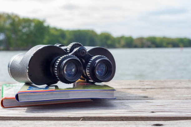 binoculars and field guides out on the pier at the river watching for wildlife - binos imagens e fotografias de stock