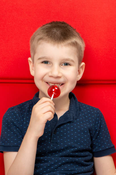 istock Little Boy Eating Red Lollipop 1140210772