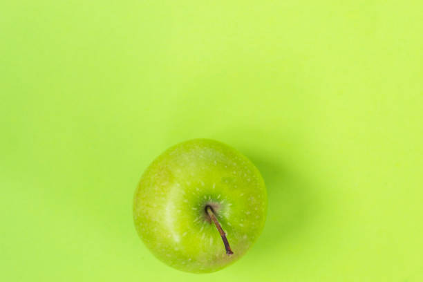istock Green apple isolated on green background 1140210783