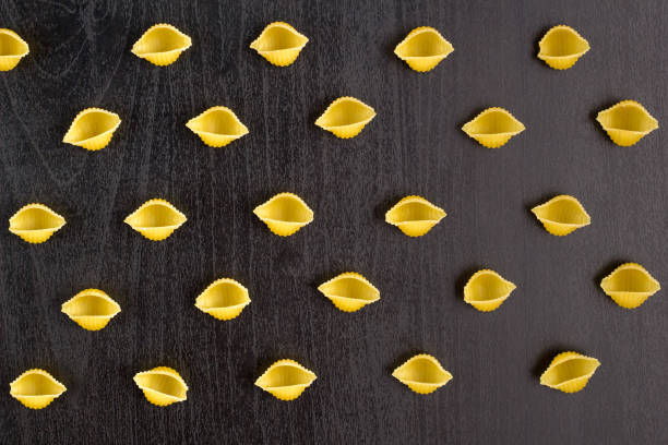 istock Pattern of A pile of conchiglie paste shells on black background 1140212795