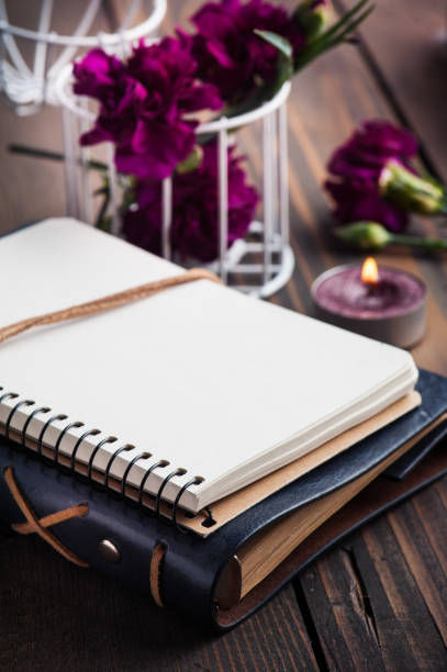 istock Bunch of purple carnations and notebook 1140217720
