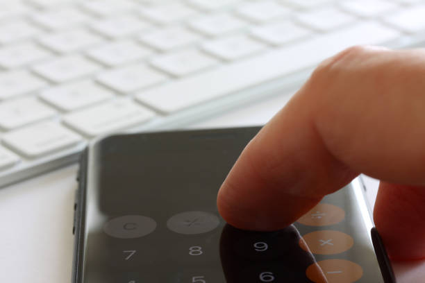 istock Smartphone with fingers touching the screen and keybord in background. Selective focus and extreme close up and hard contrast fading out for copy writing 1140218380