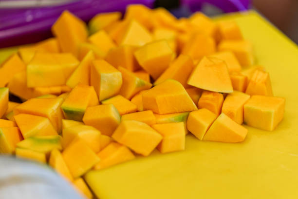 Cutted Pumpkin Pieces on the Yellow Plastic Board - Kitchen Set