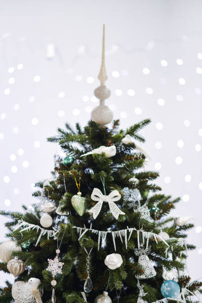 istock white winter Christmas decor for studio with a Christmas tree, in bright white shades. Christmas decorations toys, candles, fir branches 1140221246
