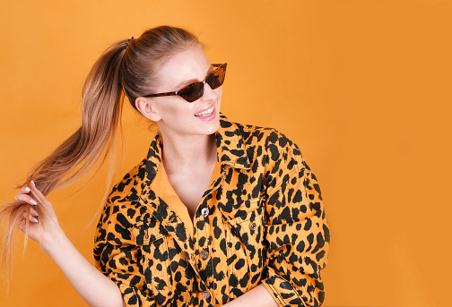 Charming blonde girl  in casual animal printed clothes in a colorful background.