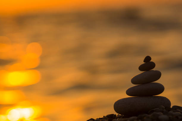 pila di pietre zen su pebble beach - cornerstone stability pyramid stone foto e immagini stock