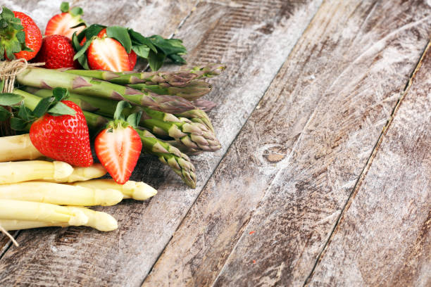istock White and green asparagus with strawberries on wood 1140222844