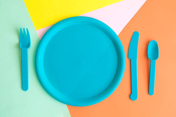 istock Flat lay of empty blue pastel plastic dish, spoon and fork abstract. Food and drink restaurant accessories utensil on table concept. 1140225432