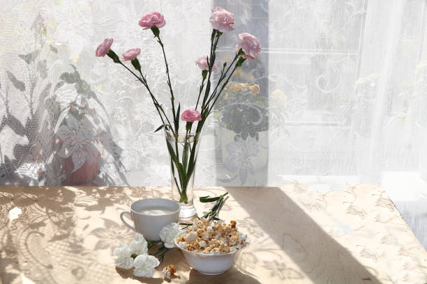 istock A mug of milk and a cup with popcorn on a sunny table, 1140244303
