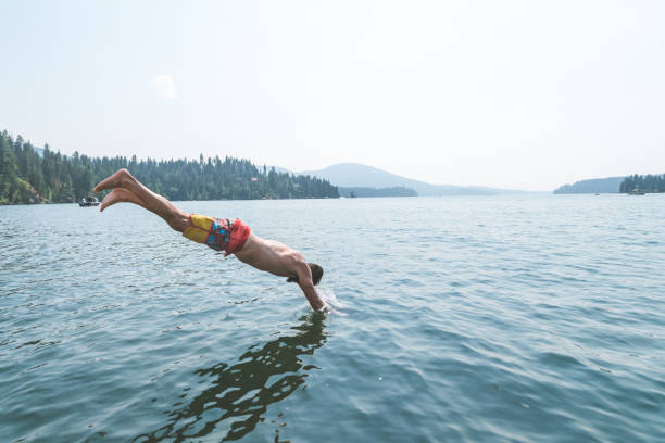 istock Young man dives into a pristine lake 1140252190