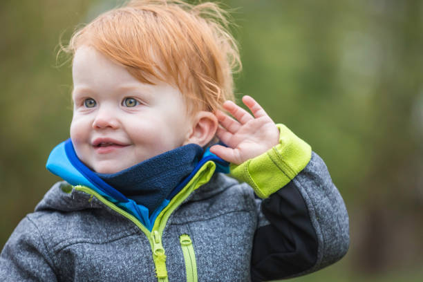 自然を聴く小さな男の子は屋外で聞こえる - listening human ear communication human hand ストックフォトと画像