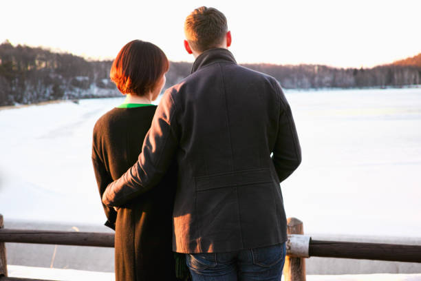 istock A young couple holding each other close while looking at Winter scenery 1140260168