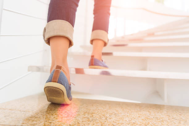 mujer adulta joven caminando por las escaleras con fondo de deporte de sol. - black ladder white staircase fotografías e imágenes de stock