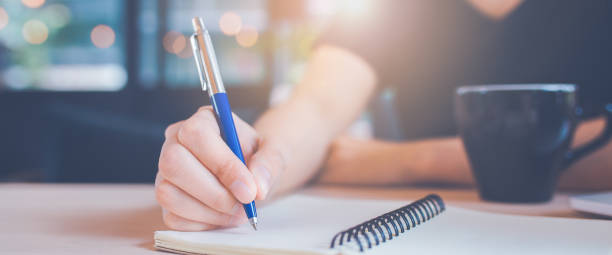istock Woman hand is writing on a notebook with a pen in office. 1140263211