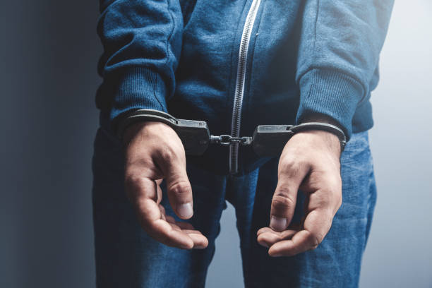 istock young man hand handcuffs on dark background 1140264943