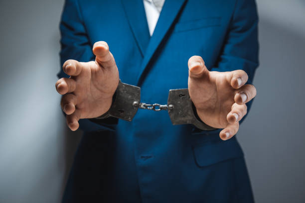 istock young man hand handcuffs on dark background 1140264947