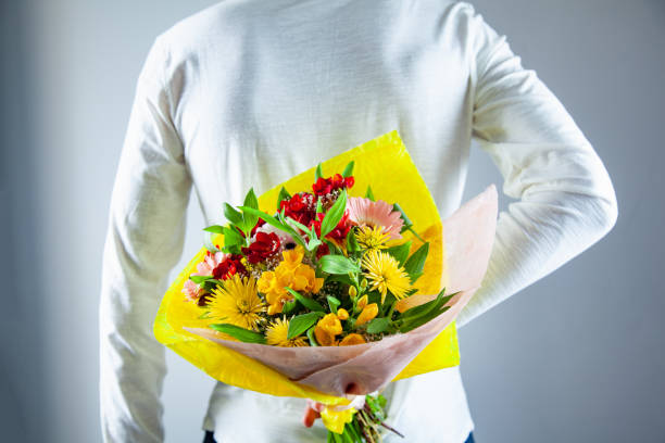 istock man hand flowers bouquet in back 1140264971