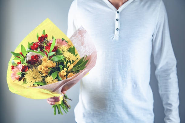 istock man hand holding flowers bouquet 1140264977