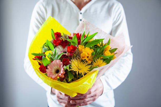 istock man hand holding flowers bouquet 1140264980