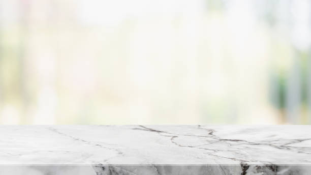 istock Empty white stone marble table top and blurred abstract background from shopping mall background - can used for display or montage your products. 1140269982