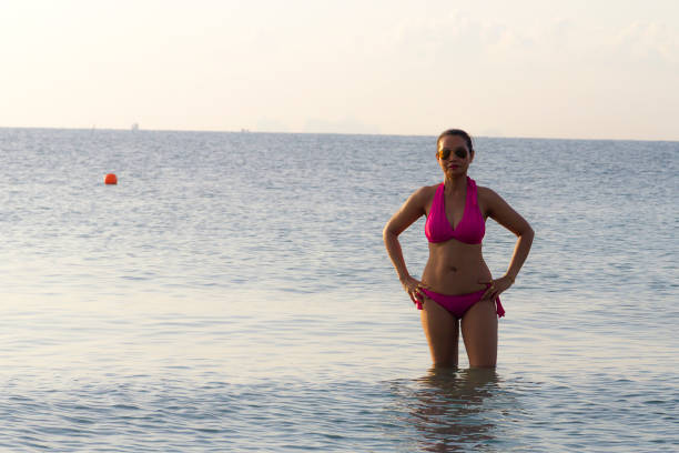 istock Woman shape sexy and bikini pink on beach 1140272829