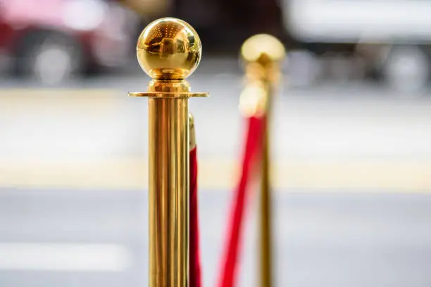 Gold metal posts holding a red velvet rope as is often used at event openings, awards ceremonies and VIP areas
