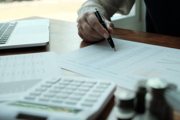 istock Businessman analyzing investment charts and pressing calculator buttons over documents. Accounting Concept  Saving Economy concept. 1140276770