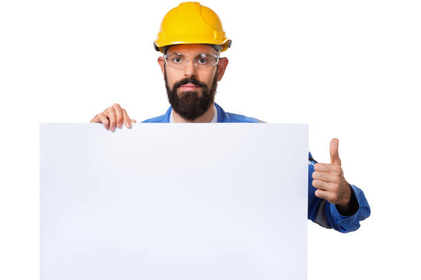 istock Builder worker in protective construction helmet raising his thumbs up and holding white advertising board with copy space, isolated 1140277831