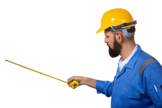 istock Handsome builder with beard is holding tape measure in his hands. Isolated on white background 1140277847