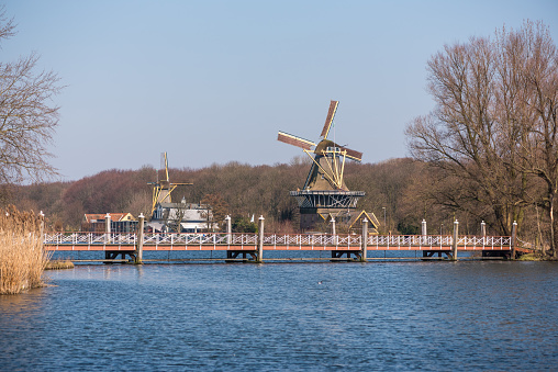 Rotterdam, Netherlands - March 17, 2016: Windmill with lake and a bridge at Kralingse Bos in Rotterdam, Netherlands