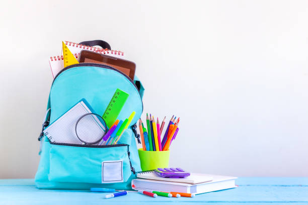 istock Full turquoise School Backpack with stationery on table. 1140285290
