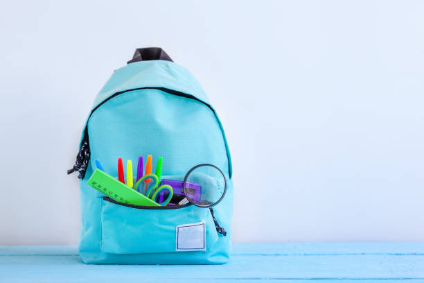 istock Full turquoise School Backpack with stationery on table. 1140285292