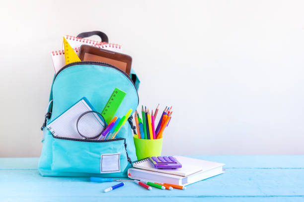 istock Full turquoise School Backpack with stationery on table. 1140285329