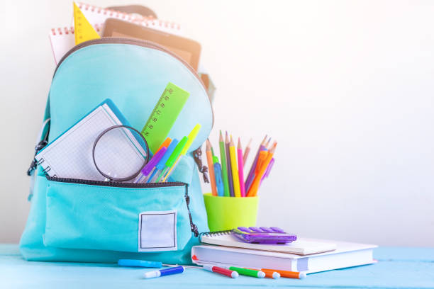 istock Full turquoise School Backpack with stationery on table. 1140285346