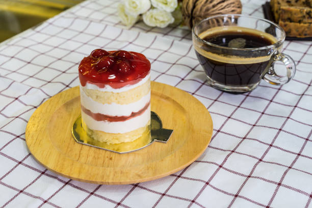 istock Cherry Cream Cake on wooden plate and coffee cup 1140288278