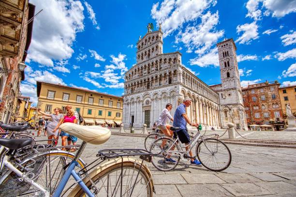 San Michele in Lucca, Italy. Lucca, Italy - June 26, 2018: View of medieval cathedral San Michele in Lucca, Italy. Tourists walking and cycling through the historic center of Lucca. lucca stock pictures, royalty-free photos & images